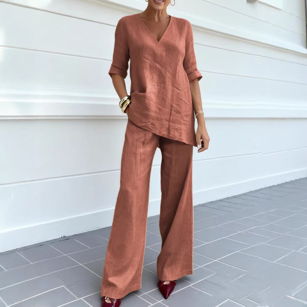 Woman wearing a brown outfit standing against a white wall.