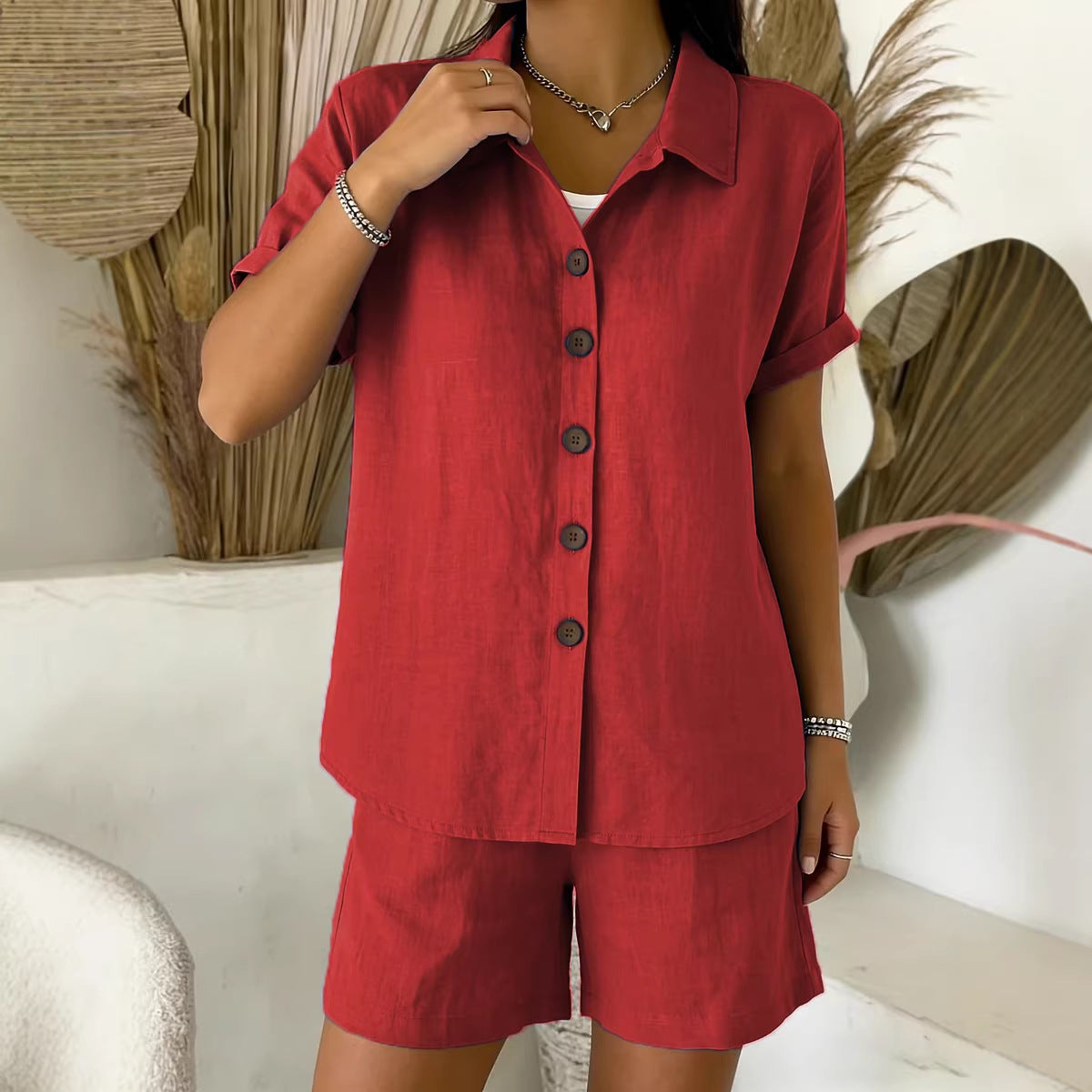 Person wearing a red outfit with a matching shirt and shorts in a minimalistic setting.