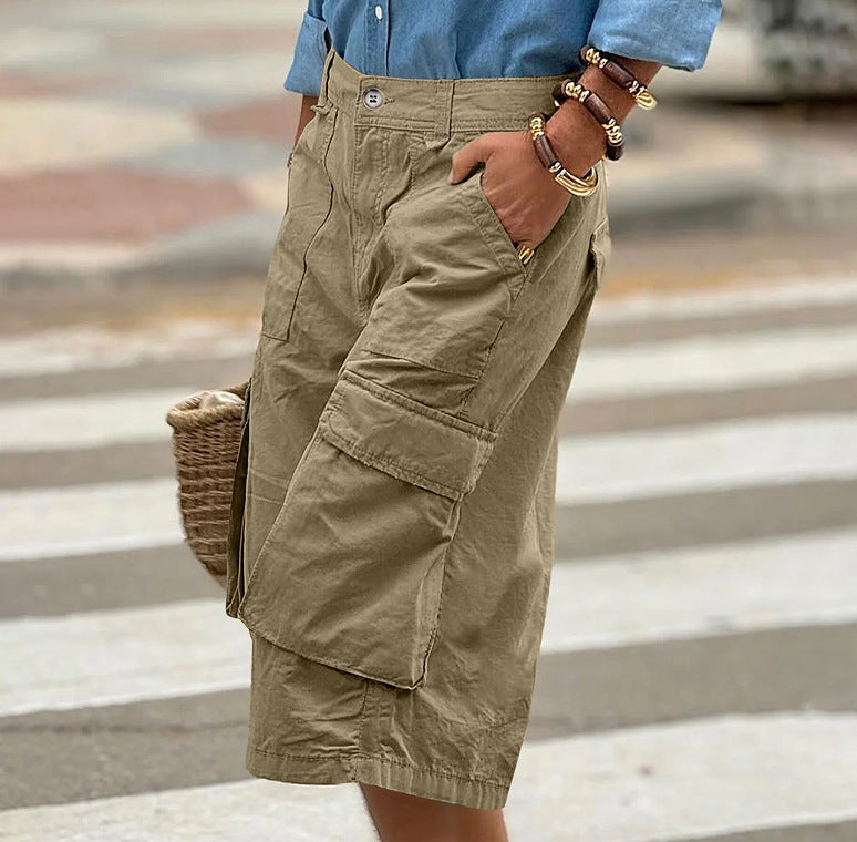Person wearing beige cargo shorts with a blurred background