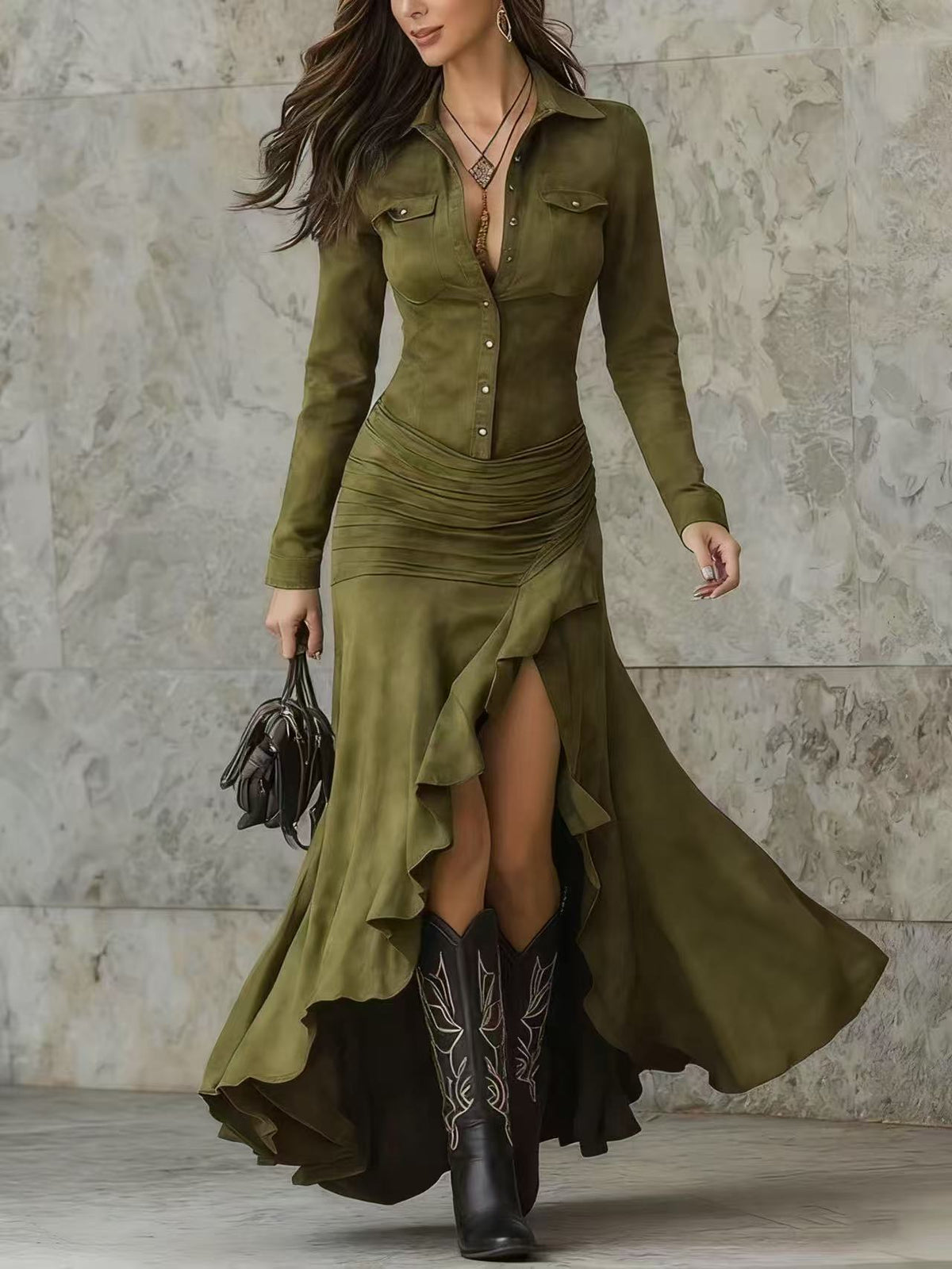 Woman wearing an olive green dress with a high-low hem and black cowboy boots against a stone wall.