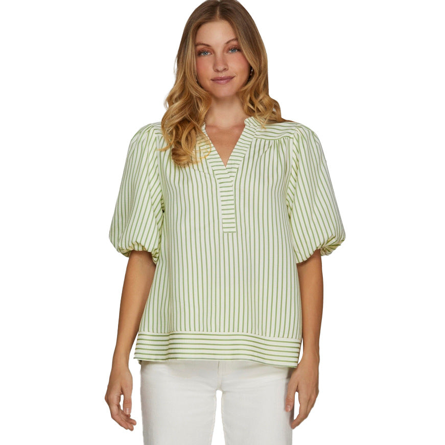 Woman wearing a light green and white striped blouse on a white background