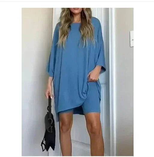 Woman wearing loose blue casual set, trendy ZA-Zola fashion, holding black handbag.