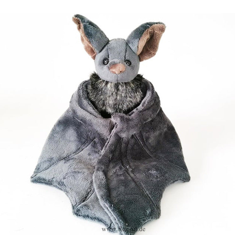 Plush toy bat wrapped in a gray blanket on a white background