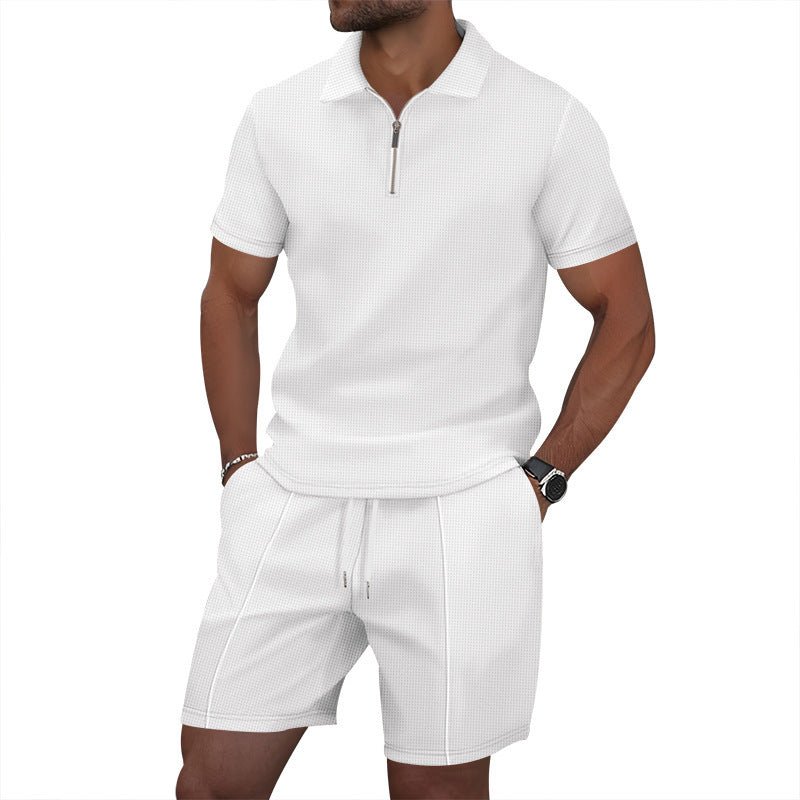 Man wearing a white polo shirt and shorts set on a white background