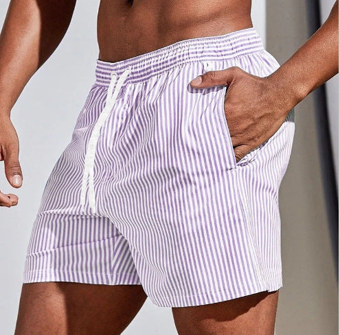 Person wearing purple and white striped shorts on a neutral background
