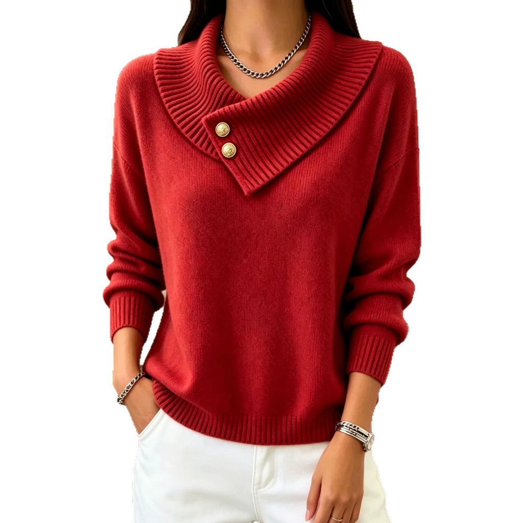 A woman wearing a red knit sweater with a wide folded collar and two gold buttons, paired with white pants, shown against a plain white background.