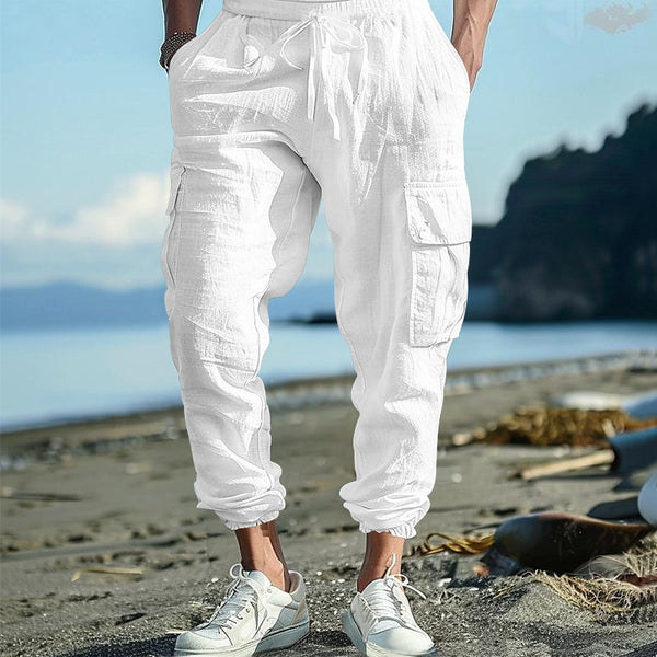 Person wearing white cargo pants and sneakers on a beach