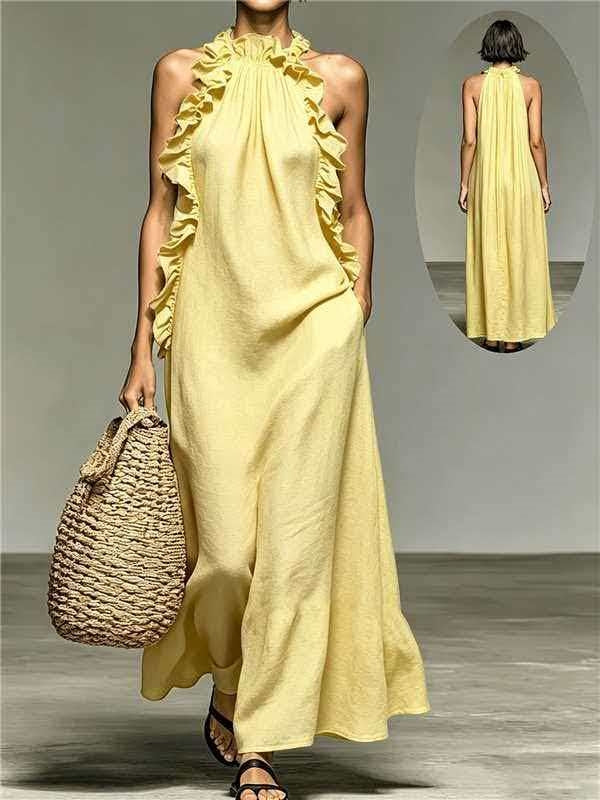 Woman wearing a yellow dress with ruffled details, holding a woven bag on a plain background.