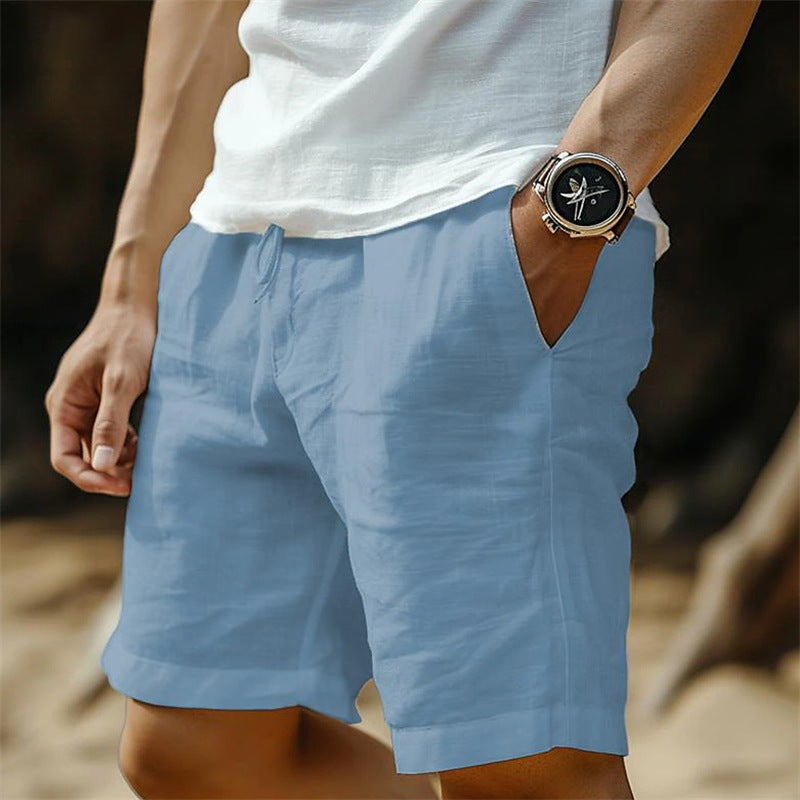 Person wearing blue shorts and a white shirt with a watch on a blurred background
