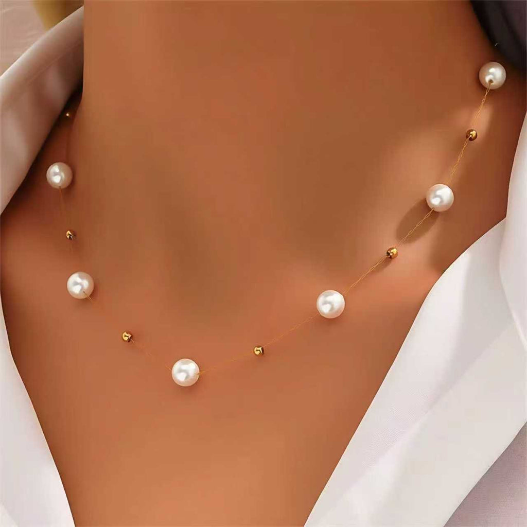Pearl necklace on a person wearing a white shirt