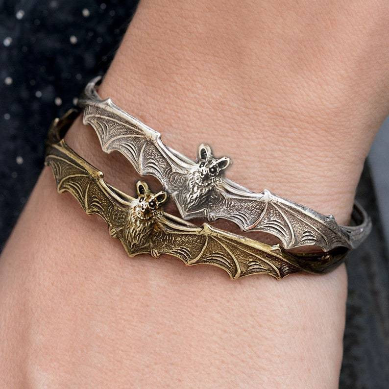 Bat-shaped bracelet on a wrist with detailed wings and open mouth design.