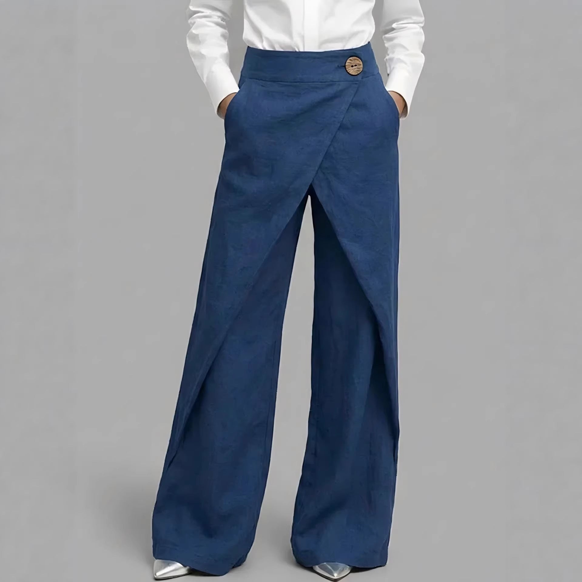 Blue wide-leg pants worn with a white shirt on a gray background