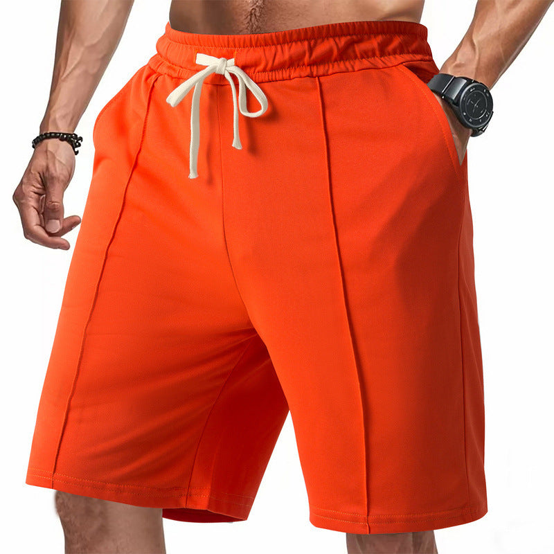 Orange shorts with a drawstring on a white background