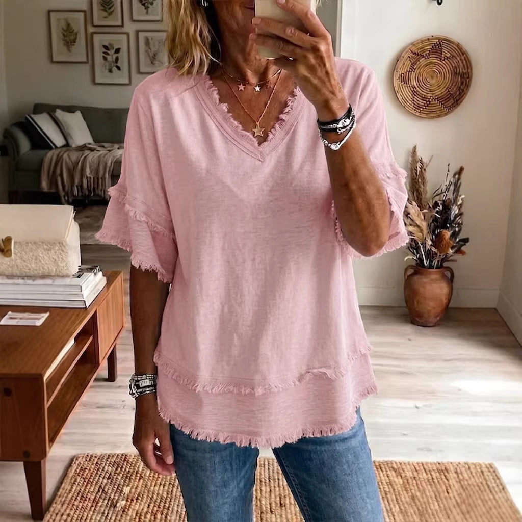 Person wearing a pink blouse and blue jeans in a living room setting.