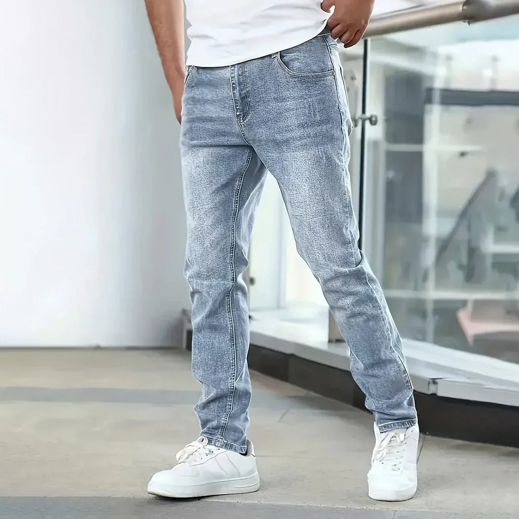 Person wearing light blue jeans and white sneakers in an indoor setting