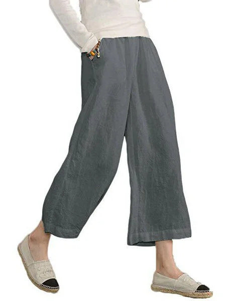 Person wearing gray wide-leg pants on a white background