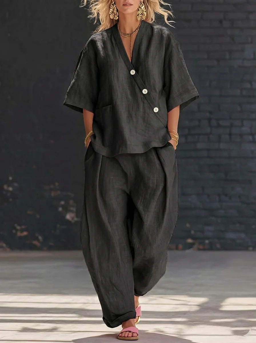 Person wearing a black outfit with a textured black wall background
