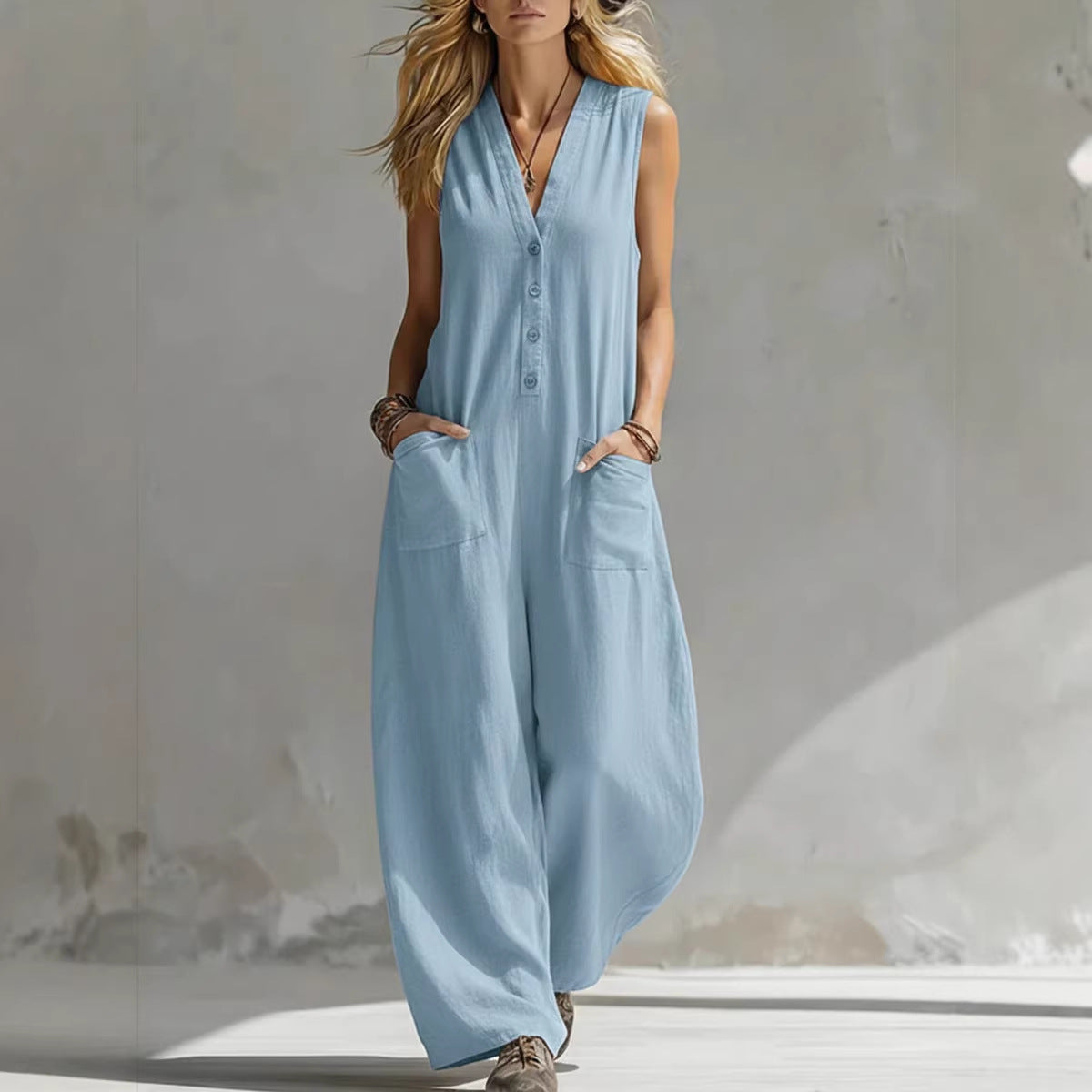 Woman wearing a light blue sleeveless jumpsuit against a neutral background