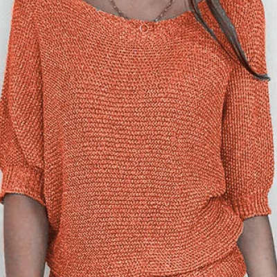 Close-up of a person wearing an orange knitted sweater with a blurred background