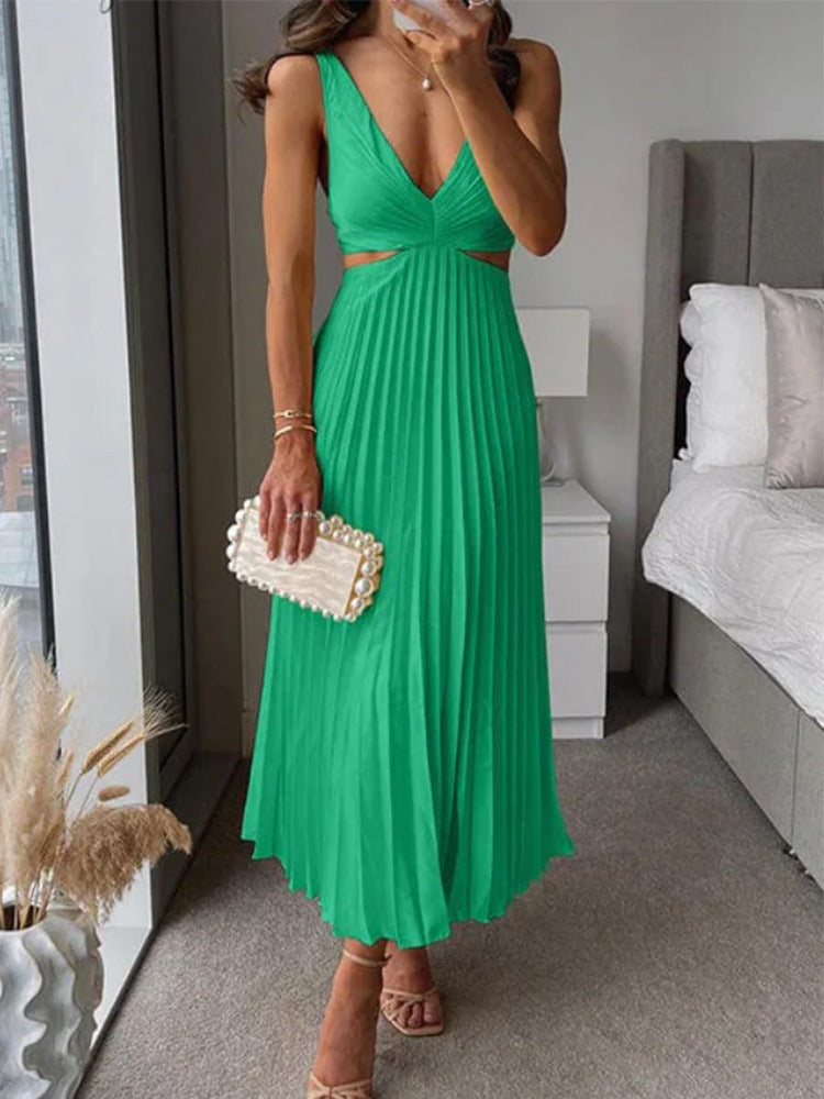 Woman in a green dress holding a clutch in a bedroom setting