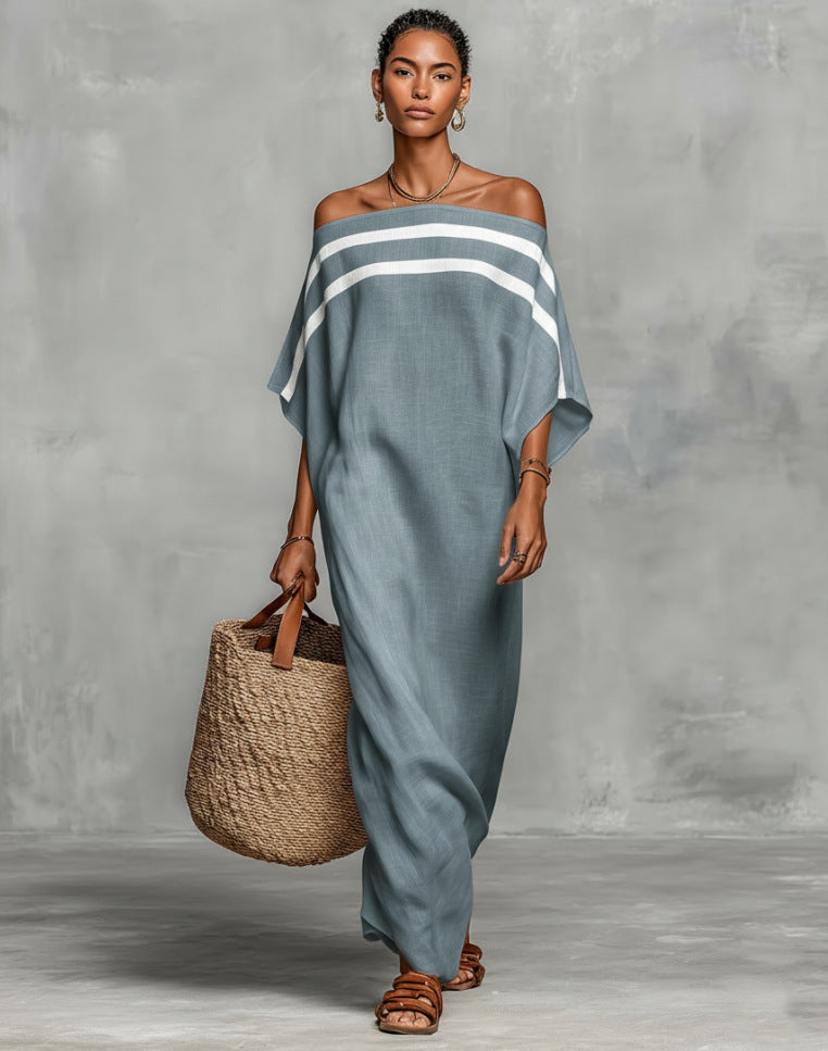 Woman wearing a blue off-shoulder dress holding a woven bag against a gray background