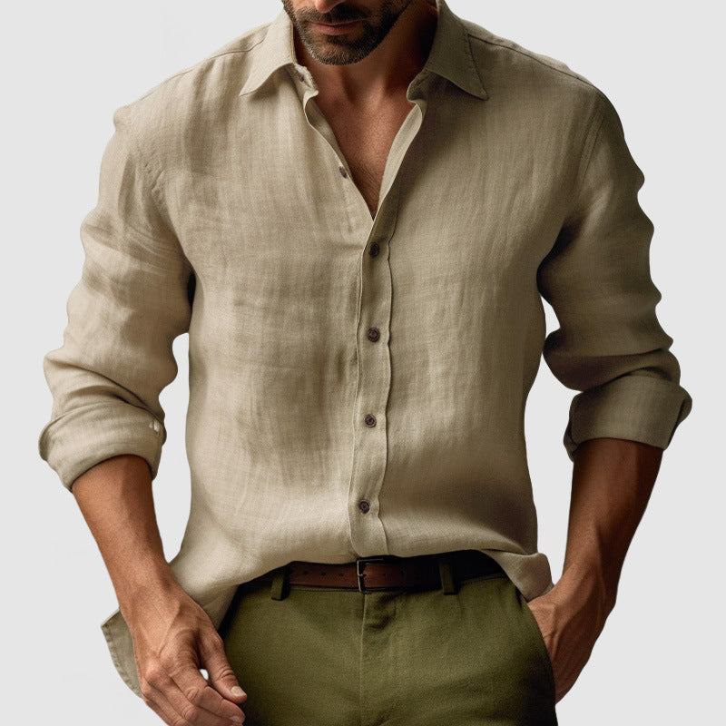 Man wearing a beige linen shirt and green pants on a plain background