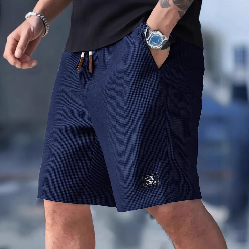 Person wearing navy shorts with a blurred background