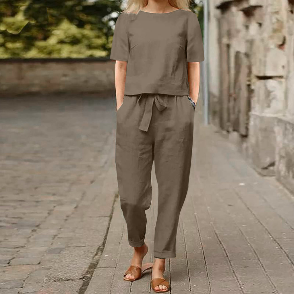 Person wearing a brown outfit standing on a stone path with a blurred background