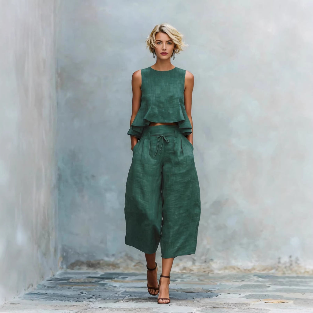 Woman wearing a green outfit against a textured wall.