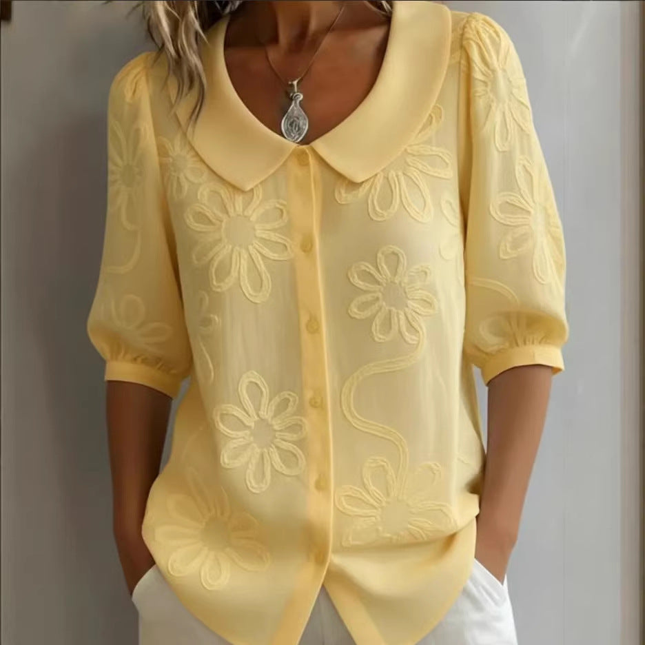 Yellow floral embroidered blouse worn by a person on a plain background