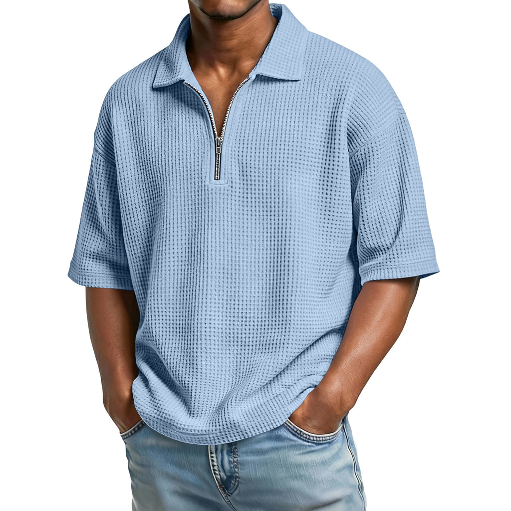 Man wearing a light blue textured short-sleeve shirt with a zipper on a white background