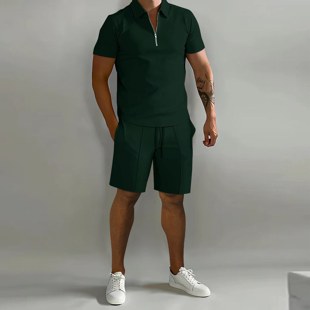 Person wearing a green polo shirt and shorts with white sneakers on a gray background