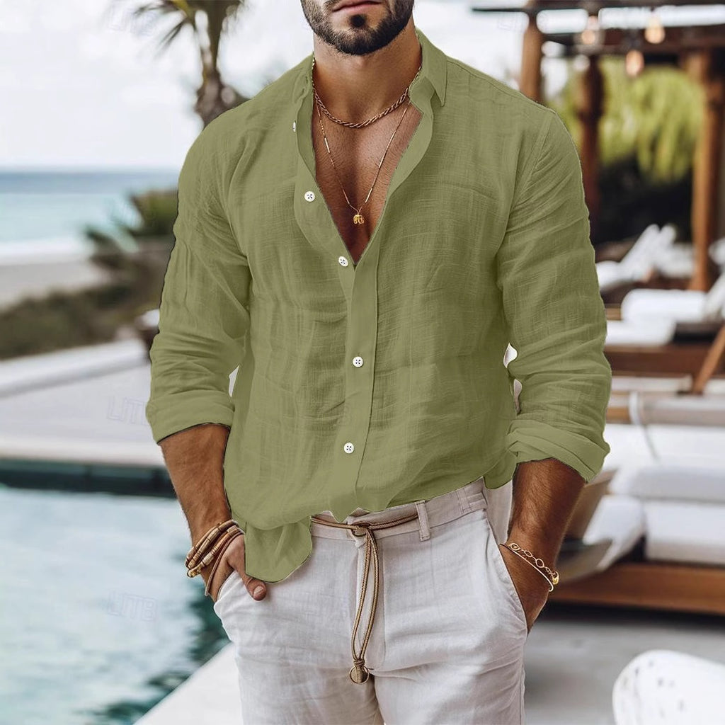 Man wearing a green shirt and white pants by a pool with a beach background