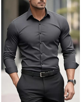 Man wearing a gray dress shirt and black pants outdoors.