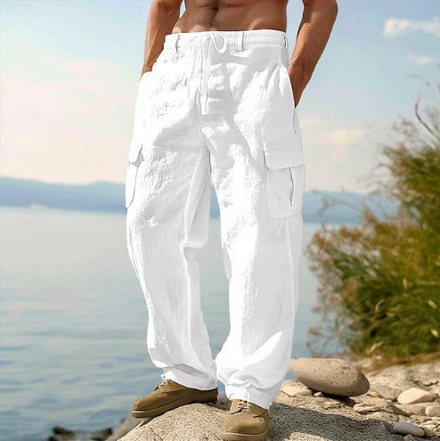 Person wearing white cargo pants standing on a rocky surface with a scenic background