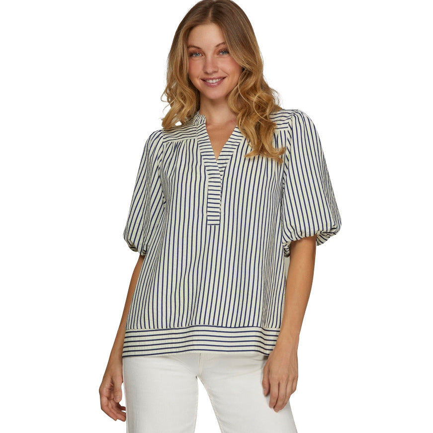 Woman wearing a striped blouse and white pants on a white background