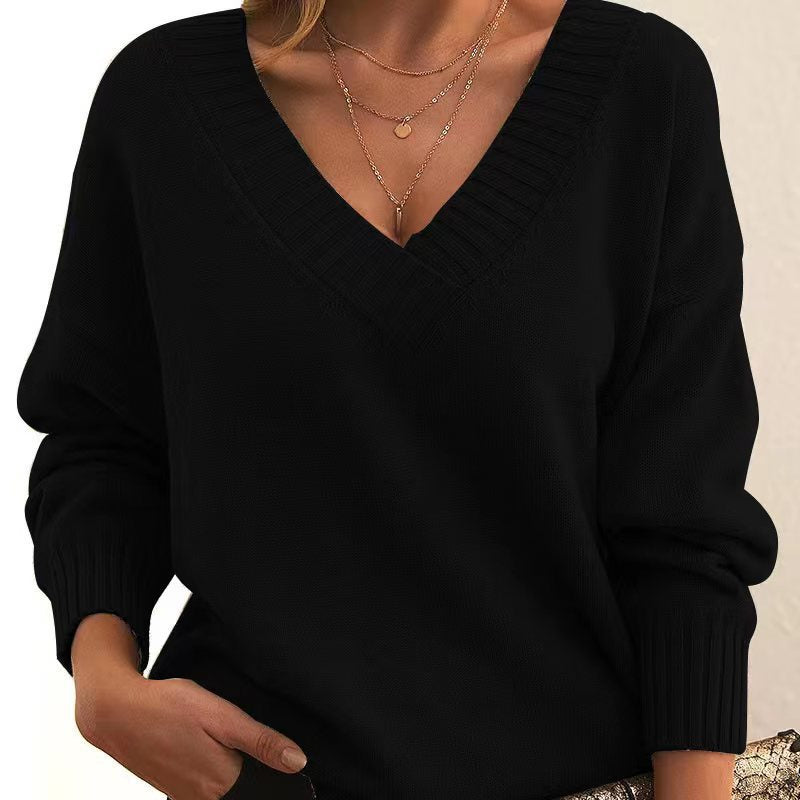 Black sweater worn by a person with a neutral background