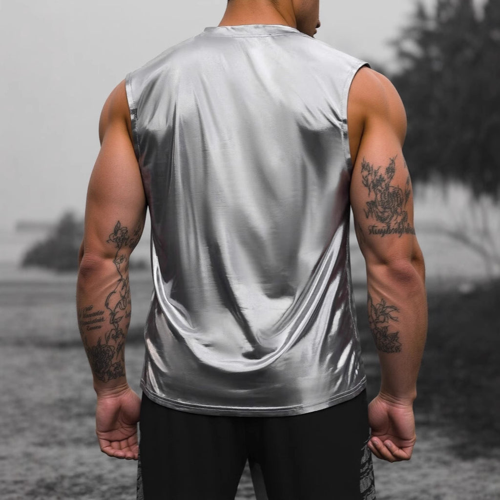 Person wearing a reflective silver tank top with tattoos on arms, standing outdoors.