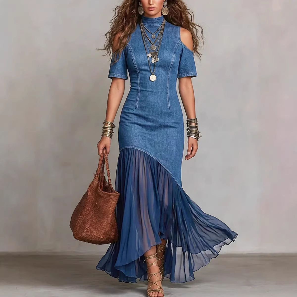 Woman wearing a blue dress with a brown handbag against a neutral background