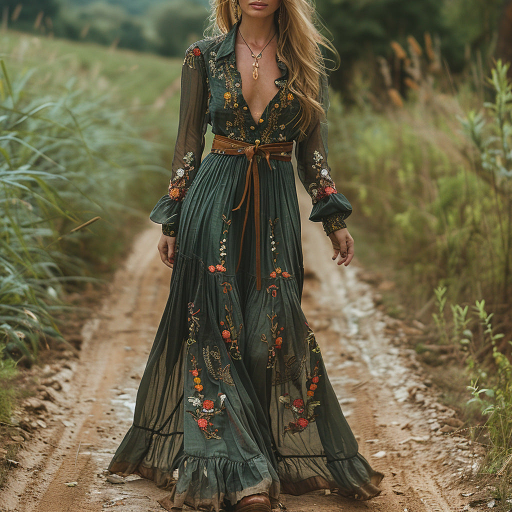 Woman in a long, dark green dress with floral patterns walking on a dirt path in a natural setting.
