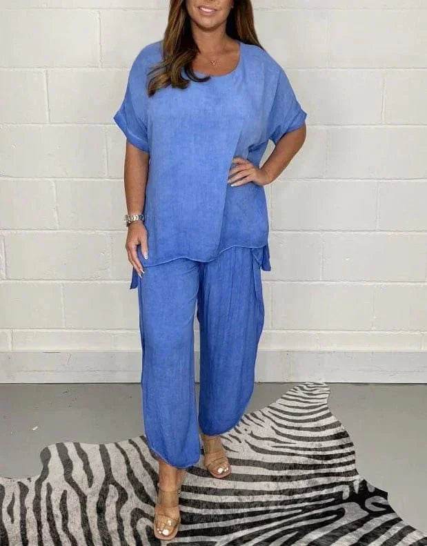 Woman modeling loose blue linen top and pants set from ZA-Zola, standing on zebra rug.