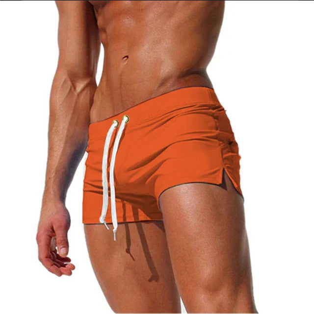 Orange swim shorts with a white drawstring on a white background