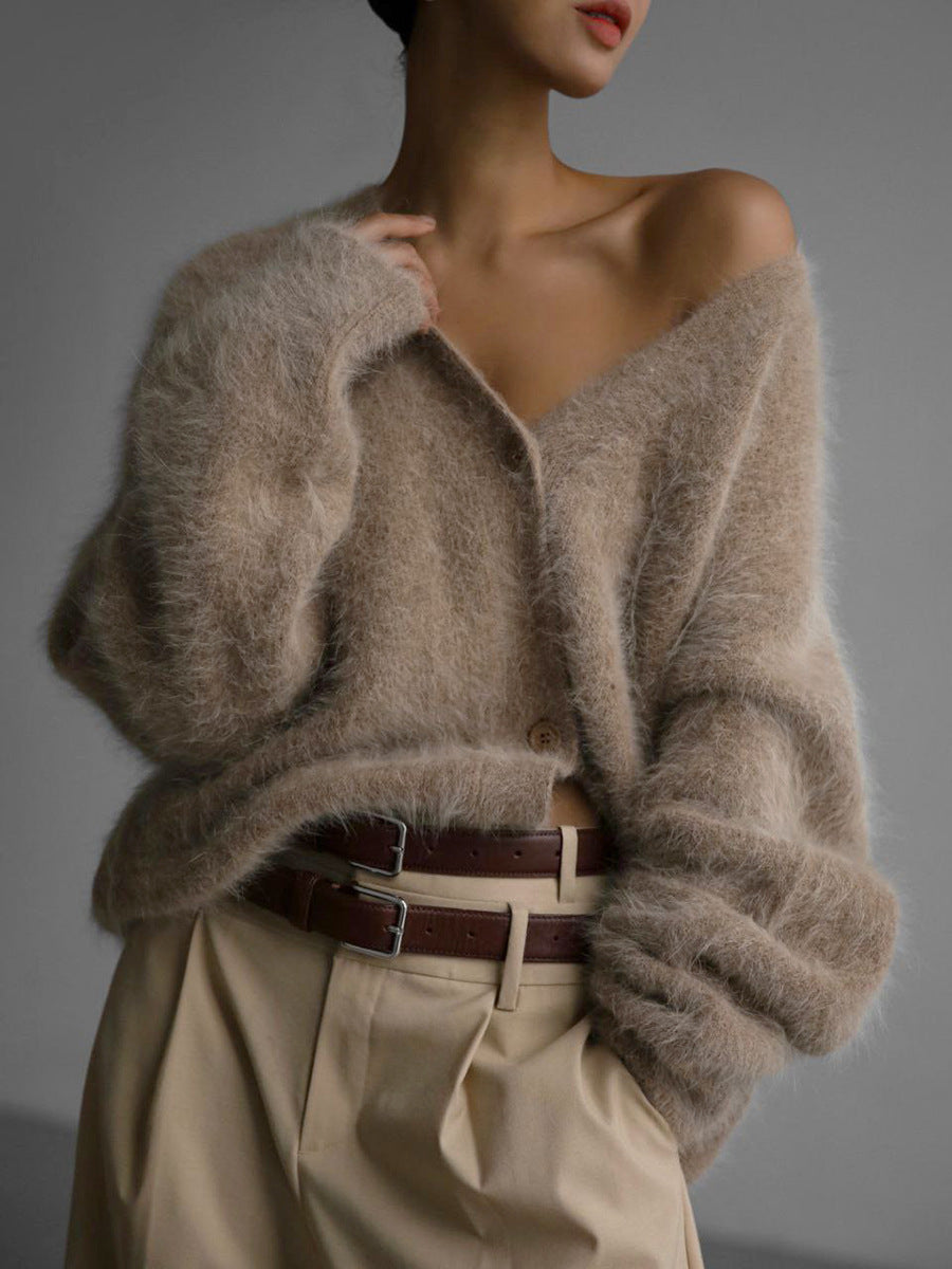Person wearing a fluffy beige sweater with a blurred background