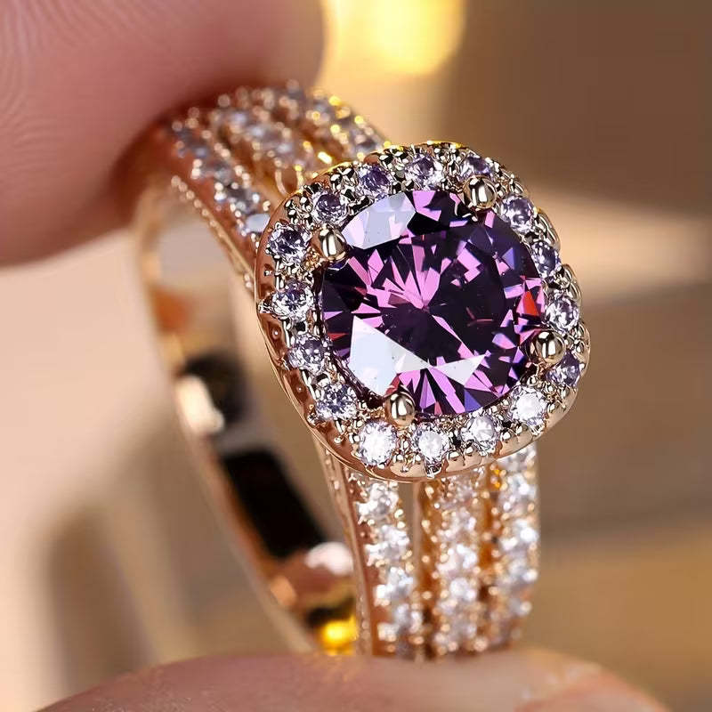 Luxury ring with a large purple gemstone held by a hand against a blurred background