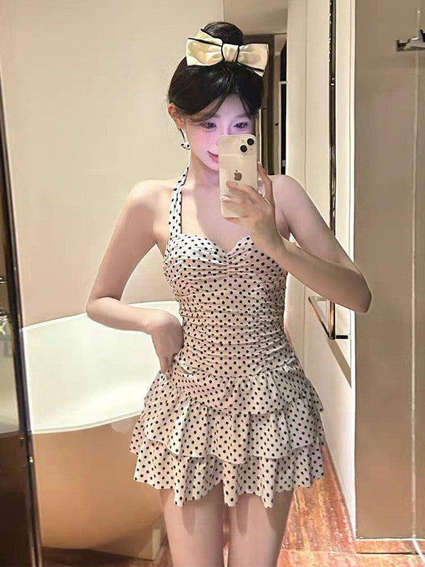 Woman taking a mirror selfie wearing a polka dot dress.