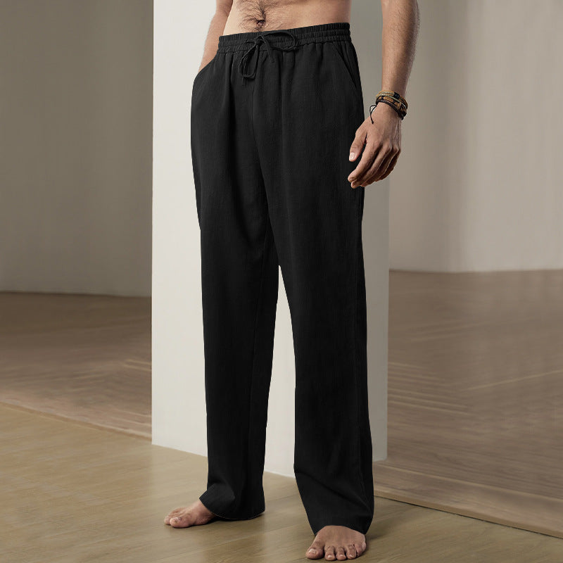 Person wearing black pants standing in a minimalistic room with a neutral color palette.