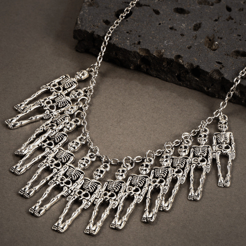 Silver skeleton necklace on a dark stone surface