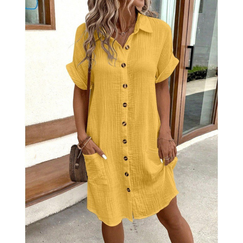 Woman wearing a yellow dress with buttons outdoors.