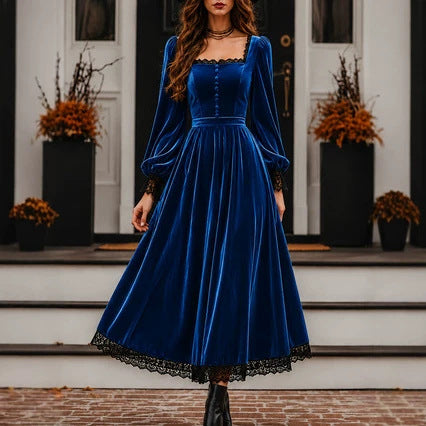 Woman wearing a blue velvet dress with long sleeves and black lace trim on a staircase.