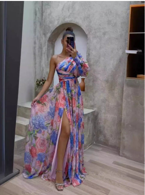 Person wearing a colorful floral dress in a room with concrete walls.